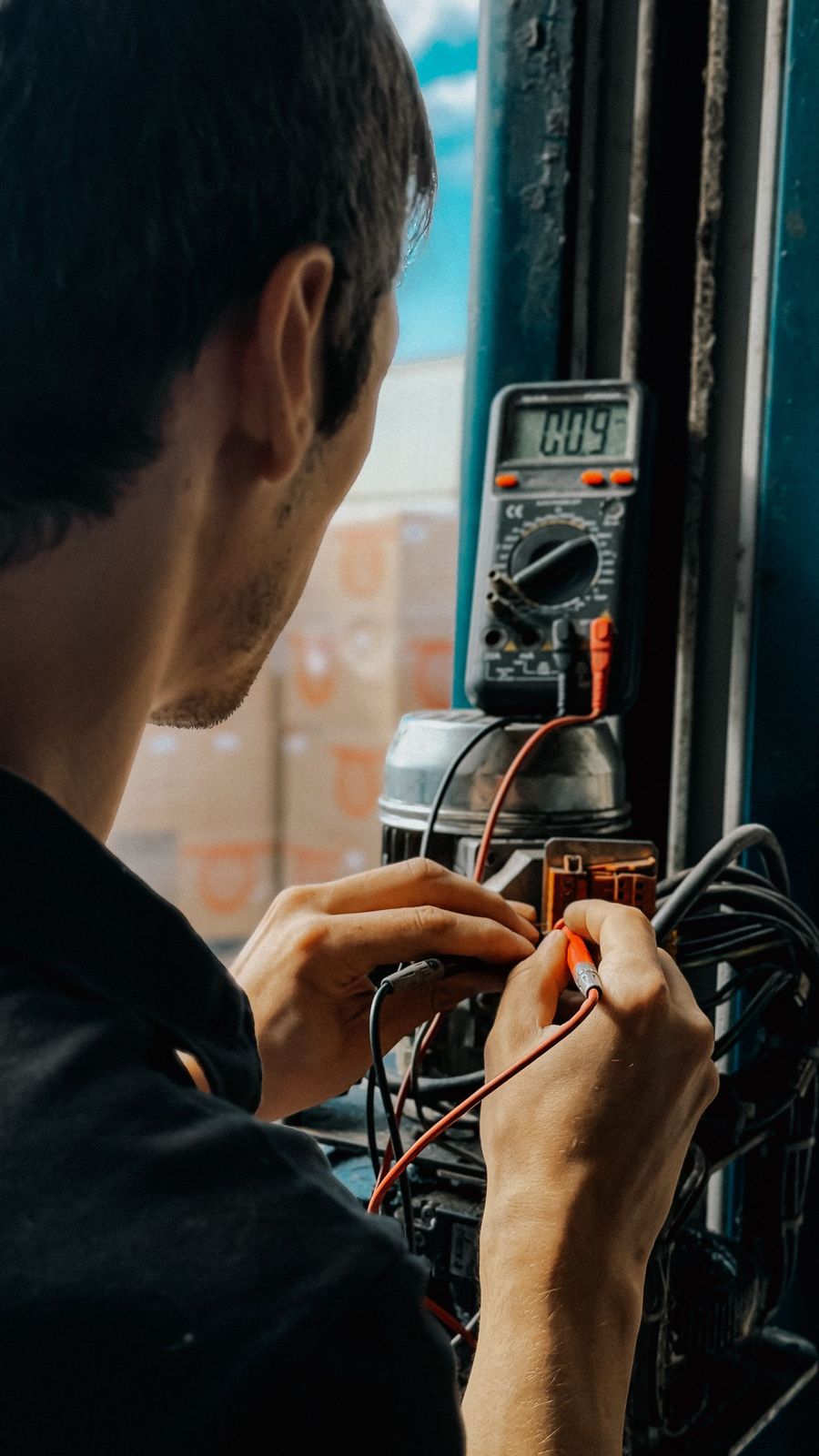 Électricien mesurant une tension sur un tableau